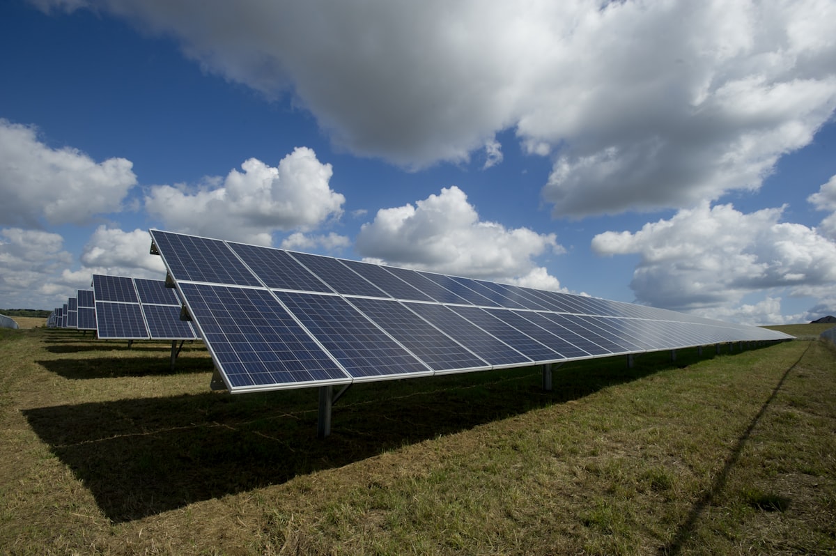 Des rangées de panneaux solaires sous un ciel bleu.